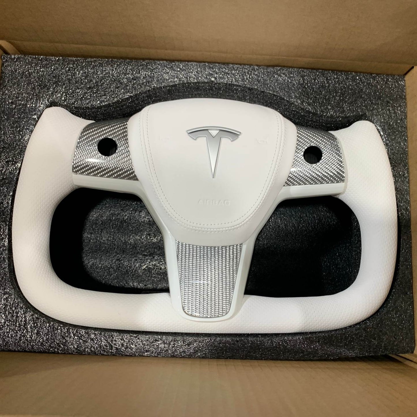 Yoke steering wheel with bright carbon or matte carbon trim with carbon side panels and heated custom speaker covers for Tesla Model 3/Y