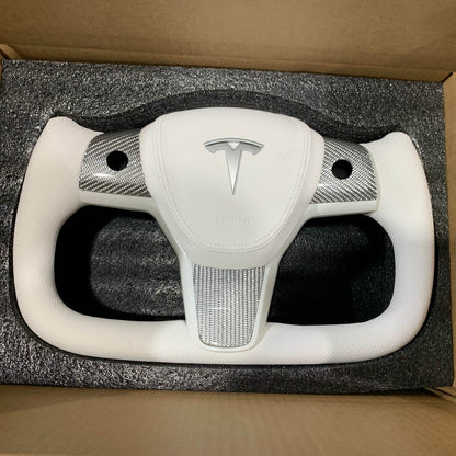 Yoke steering wheel with bright carbon or matte carbon trim with carbon side panels and heated custom speaker covers for Tesla Model 3/Y