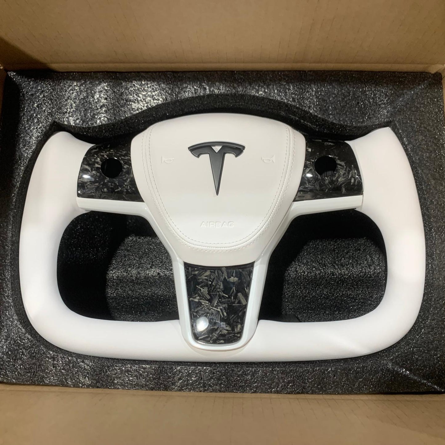 Yoke steering wheel with bright carbon or matte carbon trim with carbon side panels and heated custom speaker covers for Tesla Model 3/Y